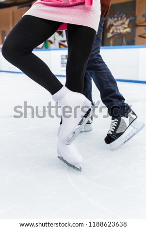 Low section of a figure ice skater couple dancing on ice rink