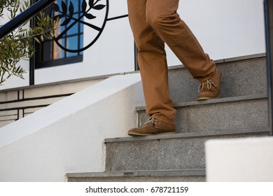 Low section of man moving down on steps