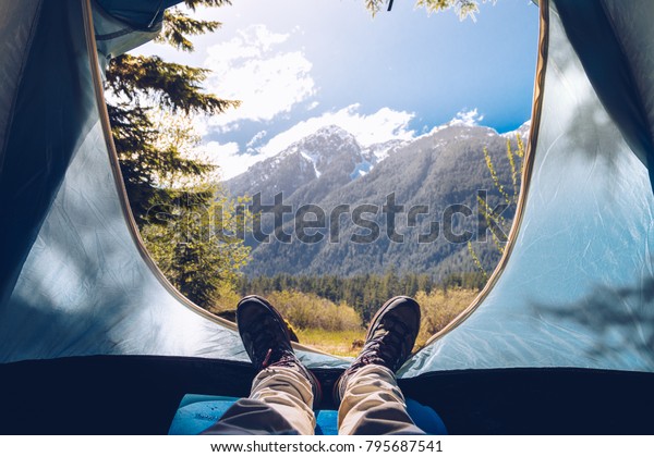 Low section of man resting in tent with\
personal perspective
