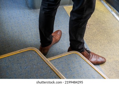 Low section of a man in shoes on a bus, a man's legs at the exit of the bus, a trip in public transport, leather men's shoes - Powered by Shutterstock