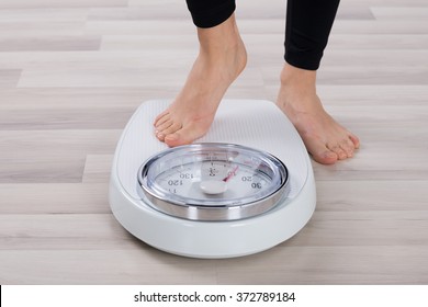 Low Section Of Person Standing On Weighing Scale