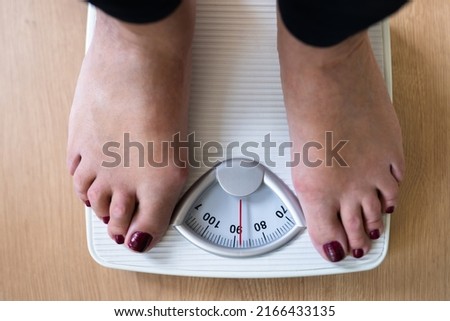Low Section Of A Person Standing On Weighing Scale