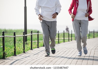 Low section portrait of unrecognizable active senior couple enjoying morning run outdoors in sunlight, copy space