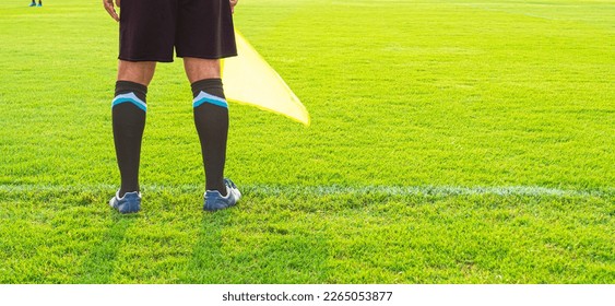 Low section of Soccer assistant referee (Linesman) standing on the edge of field, panoramic view with copy space 
