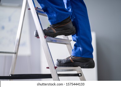 Low Section View Of A Handyman's Foot Climbing Ladder