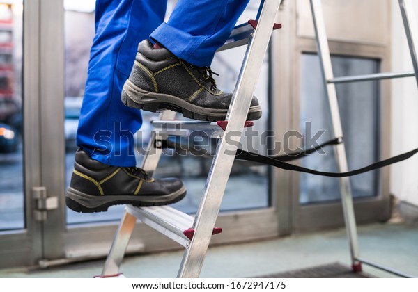 Low\
Section View Of A Handyman\'s Foot Climbing\
Ladder