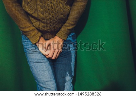 Low Section View Of Person's Wet Jeans Standing On Carpet.