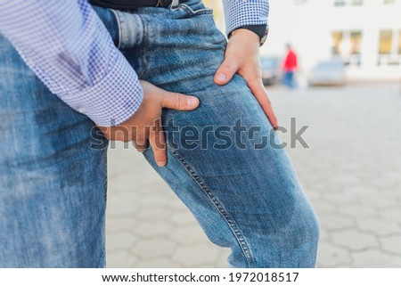 Low Section View Of Person's Wet Jeans Standing On Carpet.