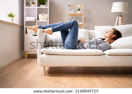 Low Section View Of A Woman Relaxing On Sofa
