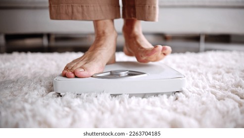 Low Section Of Woman Standing On Weight Scale - Powered by Shutterstock