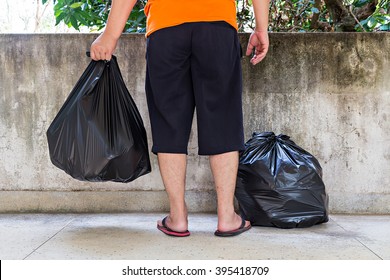 Low Section Of A Young Man Carrying Garbage Bag