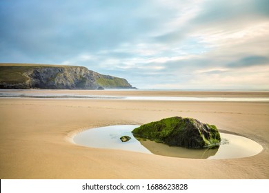 Low tide on a beach in Cornwall with tidal pools