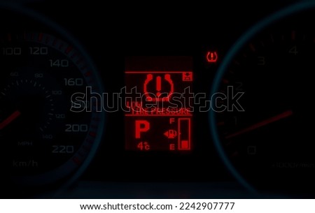 Low tire pressure warning in red on car dashboard 