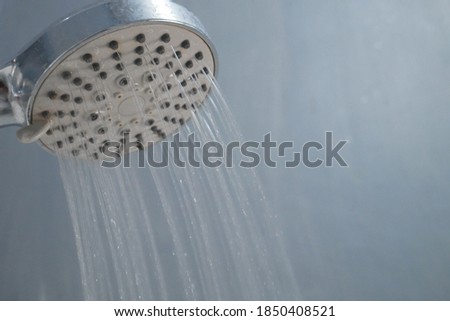 Low water pressure problem closeup at shower head in white bathroom