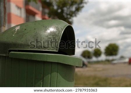 Lowangle bin with open sky and distant trees, emphasizing horizon line, spacious atmosphere and municipal object in serene suburban context
