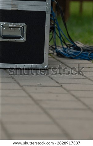 Lowangle case base on tiled pavement capturing concrete texture and foreground staging detail, subtle shadows and urban surface highlighting logistics