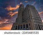 A low-angle shot of Buffalo City Hall against the background of the colorful sky at sunset. New York.