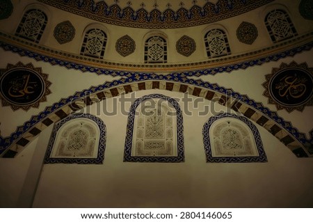 A low-angle shot of a domed ceiling with ornate mosaic patterns, arched windows, and decorative designs.
