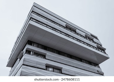 A low-angle shot of an exterior of a modern multi-storey building, featuring a variety of windows - Powered by Shutterstock