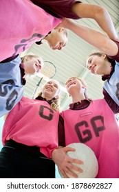 Low-angle Shot Of High School Students Talking In A Huddle Before A Netball Game.