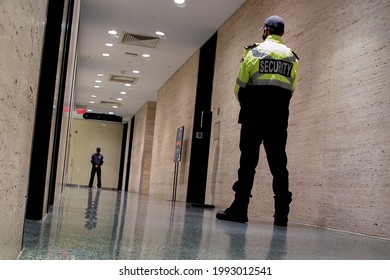 A Low-angle Shot Of Security Guards Patrolling Inside A Commercial Building 