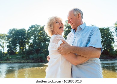 Low-angle Side View Portrait Of A Romantic Senior Couple In Love Enjoying A Healthy And Active Lifestyle Outdoors In Summer