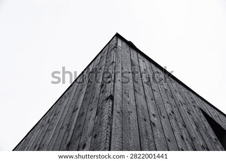 Low-angle view of a building clad in black charred timber using the traditional Shou Sugi Ban (Yakisugi) wood preservation technique, with minimalist architecture and copy space