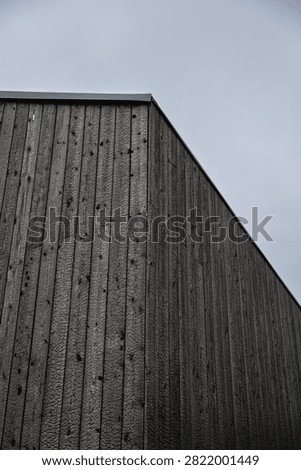 Low-angle view of a building clad in black charred timber using the traditional Shou Sugi Ban (Yakisugi) wood preservation technique, with minimalist architecture and copy space