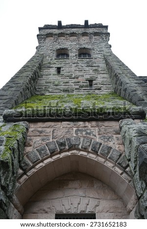 A low-angle view captures the imposing stone architecture of the Derwent Dam tower in The Peak District, England.