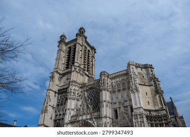 Low-angle view of Gothic facade with clock and rose window at Troyes Cathedral in Troyes, Aube, Grand Est, France.