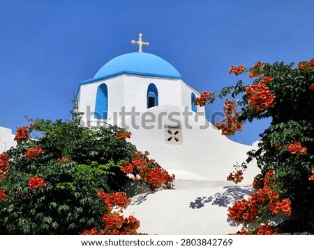 Low-angle view of the Holy Trinity (Agia Triada) Church in Parikia, Paros island, Greece—a charming whitewashed Orthodox chapel crowned with a classic Cycladic blue dome, beautifully framed by cascading orange trumpet vine blossoms beneath a crystal-clear Aegean blue sky.