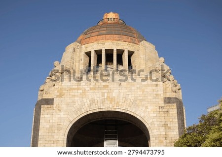 Low-angle view of the iconic Monumento a la Revolución in Mexico City, under a deep blue sky ...