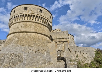 Low-angle view of the massive round tower and stone walls of Forte di San Leo
