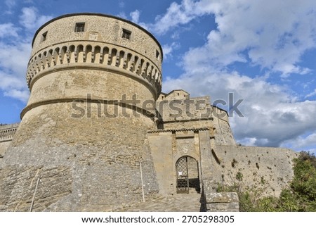 Low-angle view of the massive round tower and stone walls of Forte di San Leo