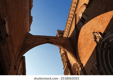 Low-angle view of Palermo Cathedral's Gothic architecture, stone details and dramatic shadows cast by the afternoon sun, historic Sicilian landmark - Powered by Shutterstock