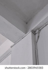 Low-angle view of a reinforced concrete column and beam inside a building with visible electrical conduit installation. The architectural perspective highlights structural geometry, making it suitable for construction, engineering, architecture, building inspection, and infrastructure concepts.