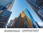 Low-angle view of skyscrapers in Manhattan reflecting sunlight against blue sky background. New York. USA.