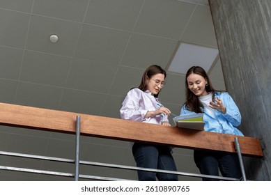 Low-angle view with two female students working together in a bright university space