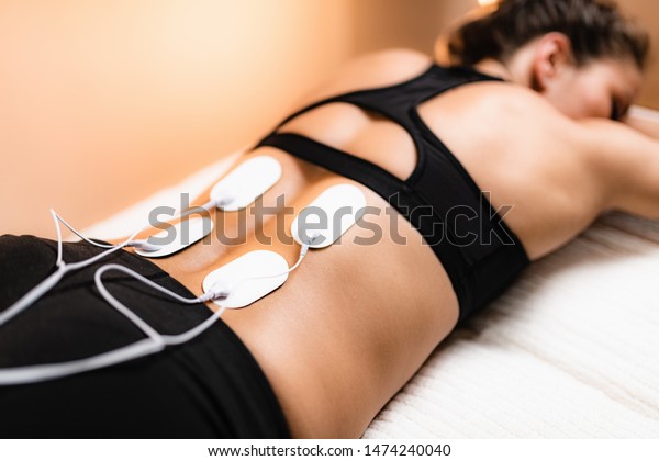 Lower Back Physical Therapy with TENS Electrode\
Pads, Transcutaneous Electrical Nerve Stimulation. Electrodes onto\
Patient\'s Lower Back