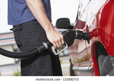 Lower Body Of A Man Refueling A Car