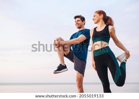 Lower couple young two friend strong sporty sportswoman sportsman woman man in sport clothes warm up training do stretch exercise on sand sea ocean beach outdoor jog on seaside in summer day morning Stock foto © 
