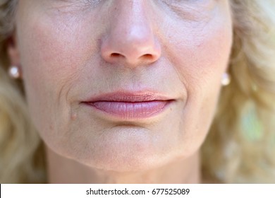 Lower Face Portrait Of An Attractive Blond Senior Lady With A Quiet Smile In A Concept Of Ageing, Wrinkles, Beauty And Skincare