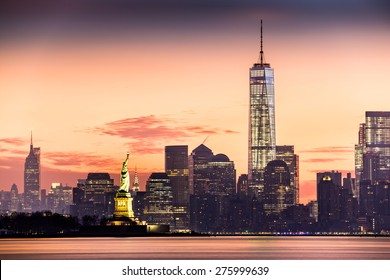 Lower Manhattan with Freedom Tower and The Statue of Liberty at sunrise