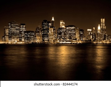 Lower Manhattan In New York City At Night With Reflection In Water