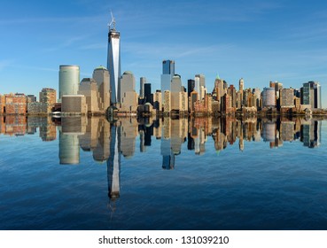 Lower Manhattan Skyline Panorama Over East River With Reflection And Blue Sky In New York City