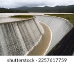 Lower Nihotupu Reservoir shows water cascading and overflowing the side walls due to record breaking heavy rainfall in New Zealand.Waitakere