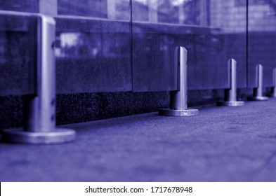 The Lower Part Of The Glass Railing Stairs. Metal Supports For Glass Fencing Panels. External Entrance To The Building. Close-up. Selective Focus.