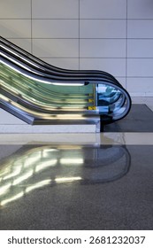 
Lower part of lighted escalator and its reflection in shiny floor
