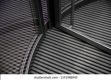 Lower Part Of Revolving Doors And Striped Floor Under Them. Abstract Modern Architecture. Steel And Glass. Close-up Photo Of Office Building Lobby / Entrance Hall Fragment.