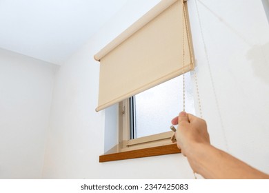 Lower the roll screen attached to the window